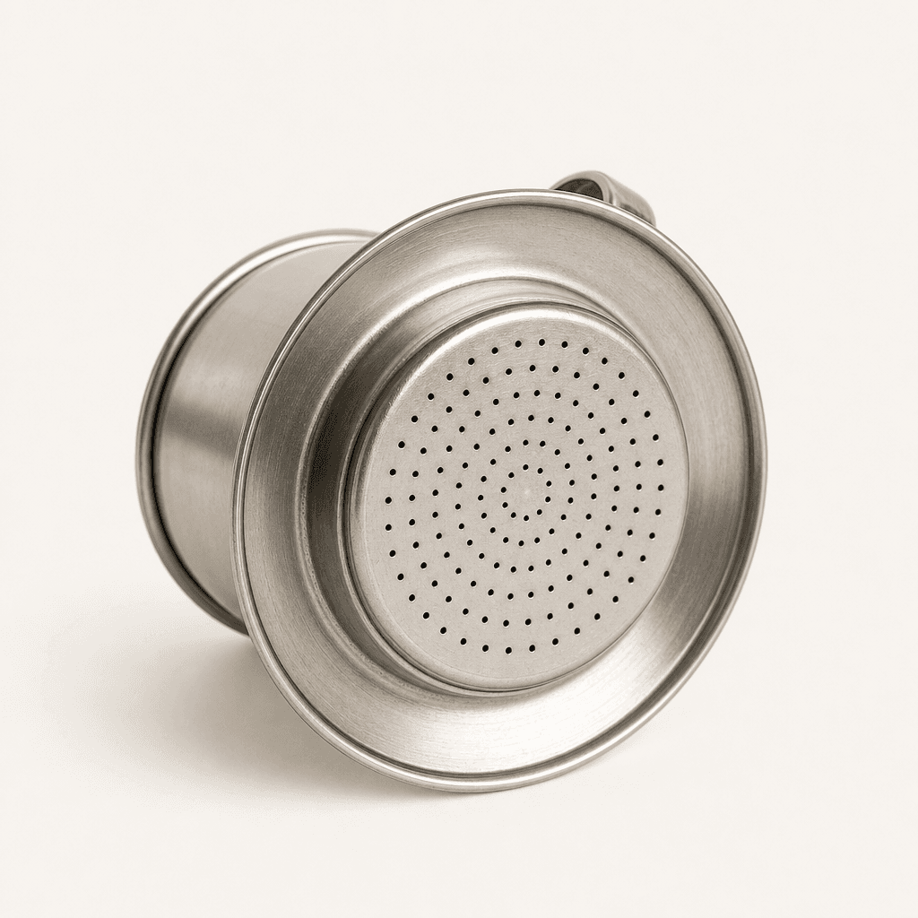 Close-up of the perforated filter base of a Vietnamese coffee dripper
