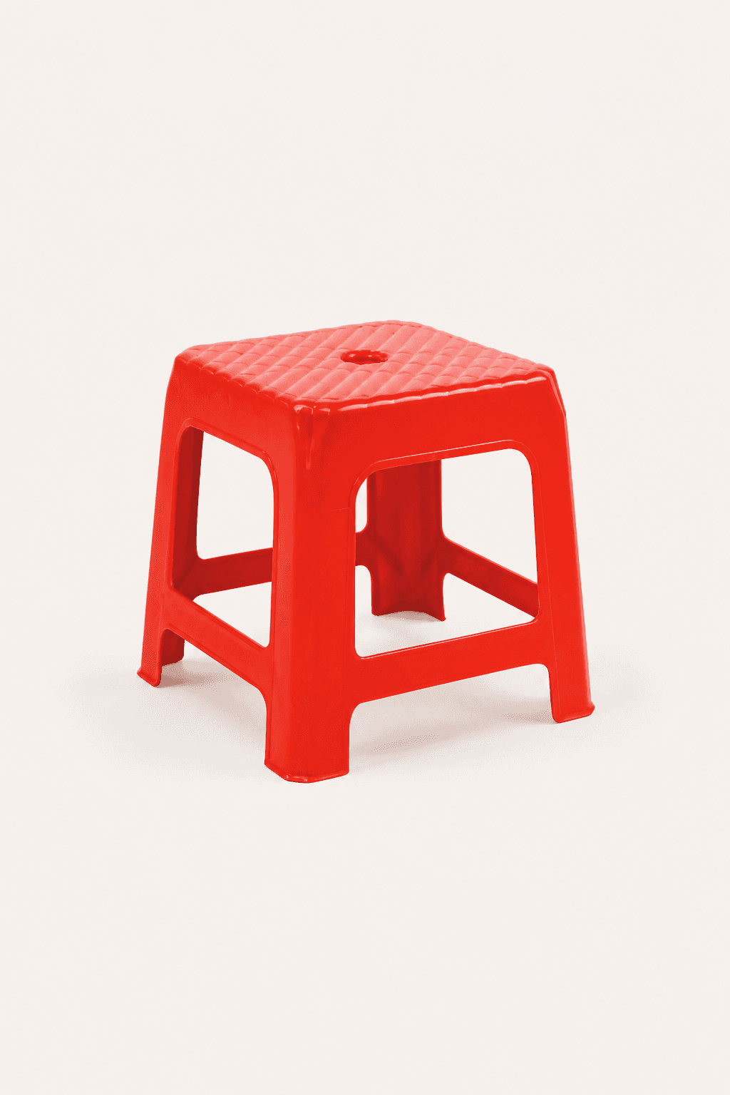 Vietnamese red plastic stool on a warm off-white background